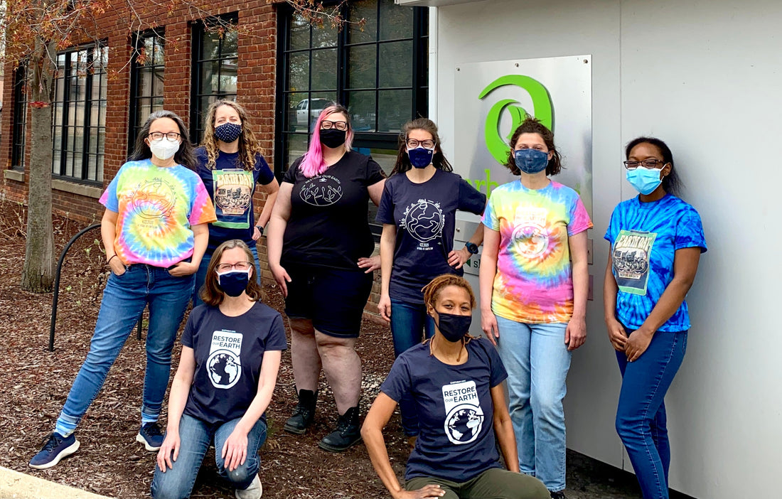 Group of Arbor Teas Staff standing in Earth Day shirts in front of sign
