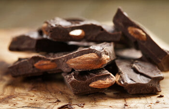 Chocolate pieces with almonds on a wooden surface