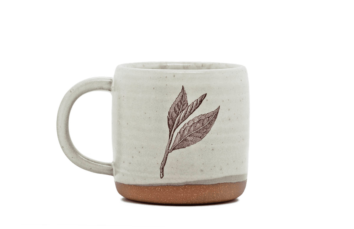 Ceramic mug with leaf design on a black background