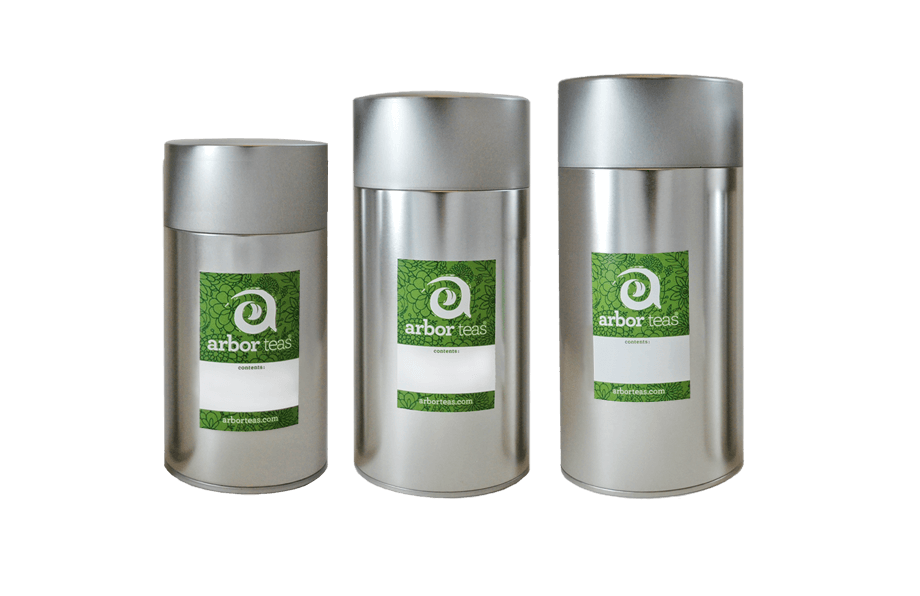 Three silver tea canisters with green labels on a white background