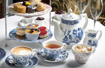 Tea set with teacups, teapot, and pastries on a table