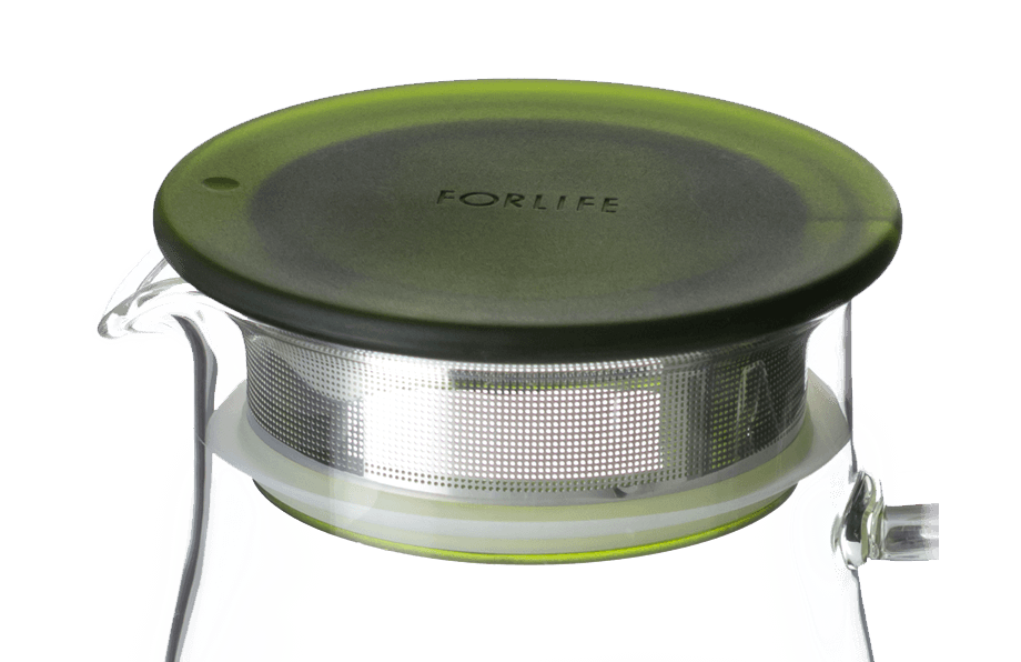 Close up of clear glass container with green lid and built in infuser