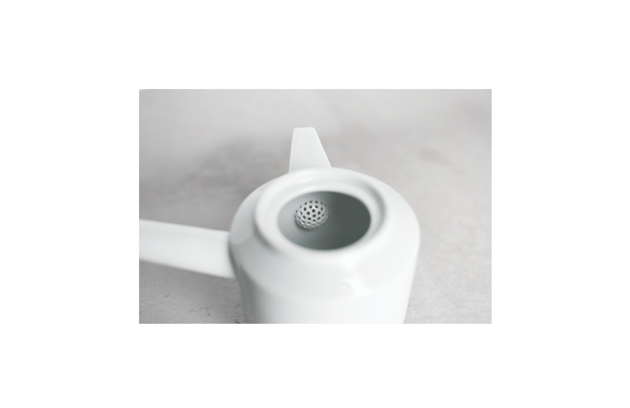 Interior view of white ceramic teapot with built-in sieve