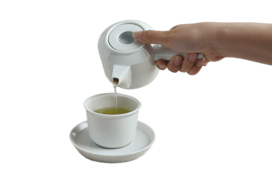 White ceramic teapot pouring tea into a white cup
