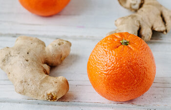 Oranges and ginger root on a wooden surface