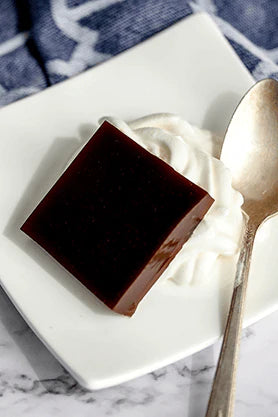 Square of Chaga Chicory Jelly with Whipped Cream on plate