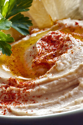 Swirl of hummus topped with a sprinkle of red paprika