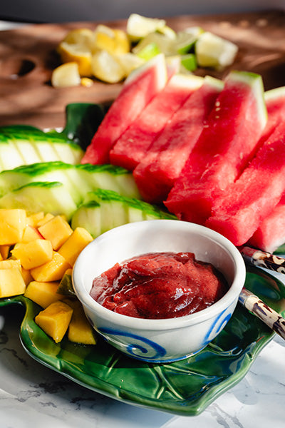 Bowl of Hibiscus Chamoy sauce surrounded by fruit