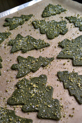 Green Matcha Pistachio Cookies in the shape of Christmas trees on cookie sheet