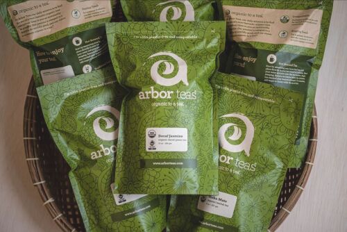 Several Green bags of tea in a basket