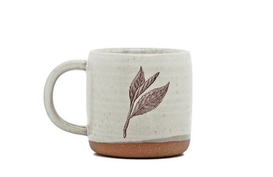 Ceramic mug with leaf design on a black background