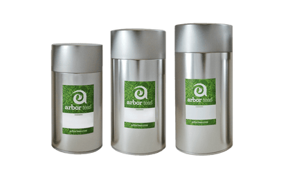 Three silver tea canisters with green labels on a white background