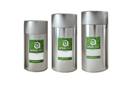 Three silver tea canisters with green labels on a white background