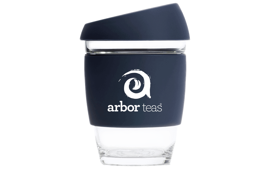 Clear glass tumbler with navy sleeve featuring 'arbor teas' logo 
