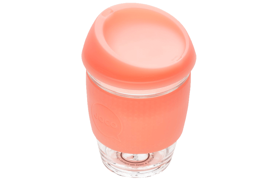 Clear glass tumbler with a coral-colored lid 