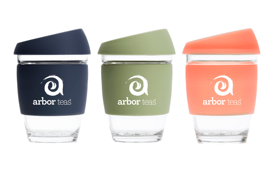 Three reusable cups with different colored lids and 'arbor teas' branding