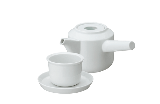 White ceramic teapot with matching teacup and saucer