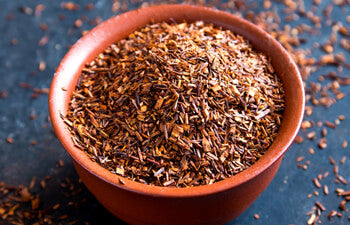 rooibos in a terracotta pot on a dark surface